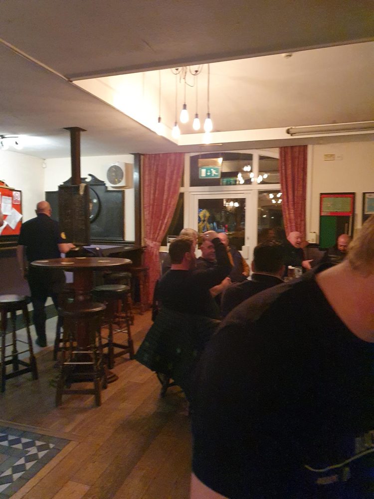 Busy pub interior with the dartboard area and pool table visible