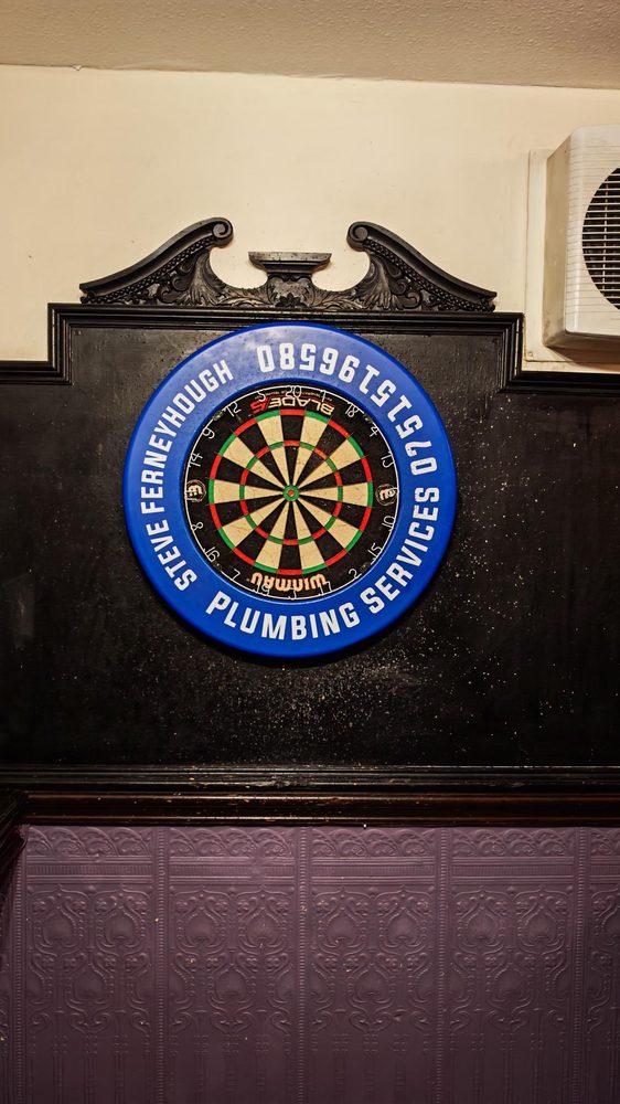 Dartboard mounted on a dark ornate wall