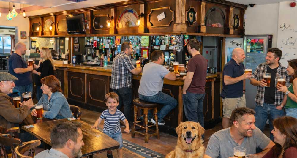 Busy pub interior with people enjoying drinks at the wooden bar